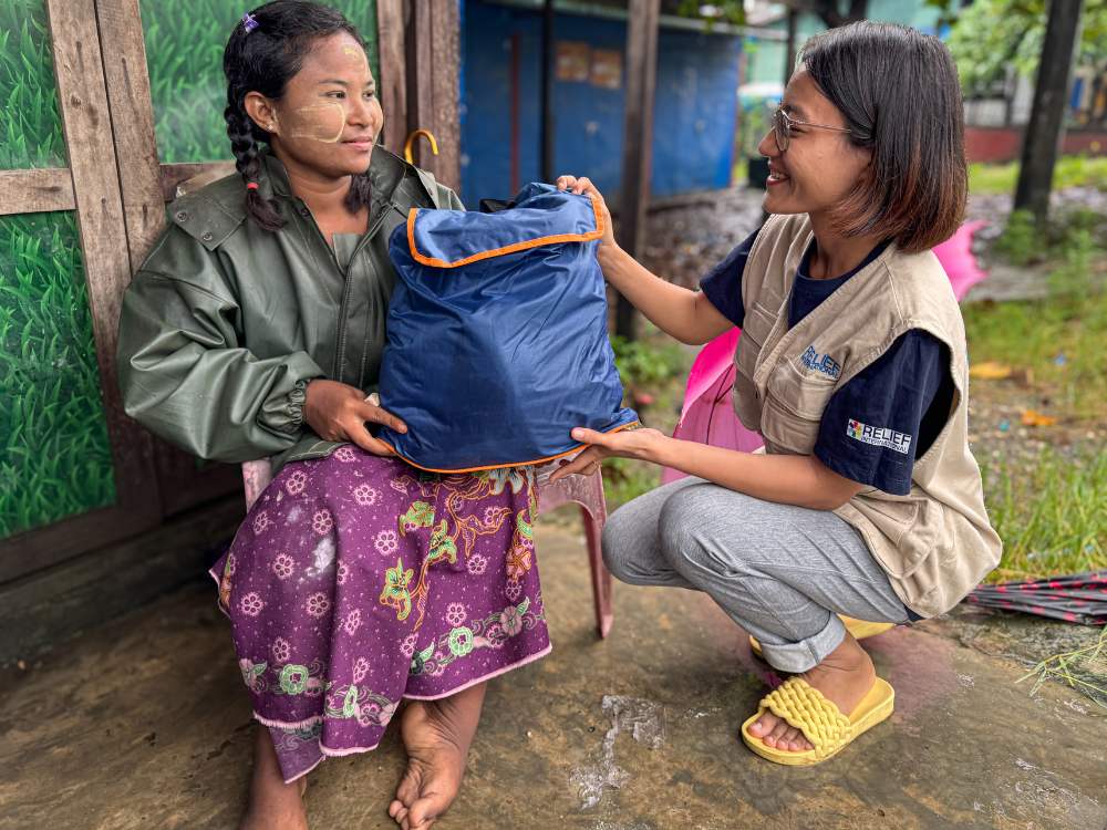 Figure 4: A woman with disability from IDP camp in Sittwe township receives dignity kits which includes essential menstrual hygiene items such as sanitary pads, underwear and soap, etc.   Photo © UNFPA Myanmar