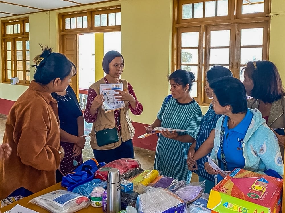 Figure 8: The UNFPA field team meet with women and girls from the flood-affected community in Shan to explain the contents of the dignity kit and raise awareness about gender-based violence.  Photo © UNFPA Myanmar