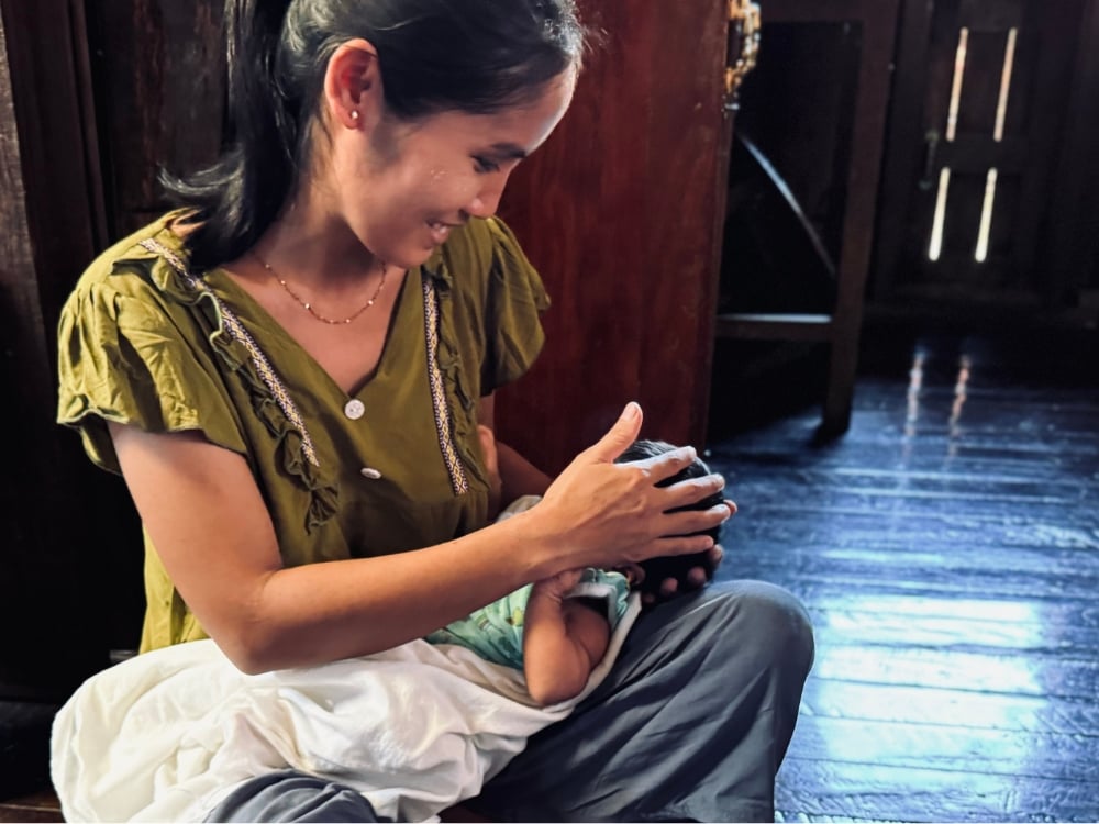 Figure 9: A mother with her newborn child from a flood-affected community receives health care at the mobile clinic. Photo © UNFPA Myanmar