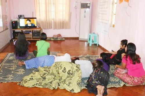 Zin Zin and her peers watch a TV show at a Sex Workers in Myanmar center.