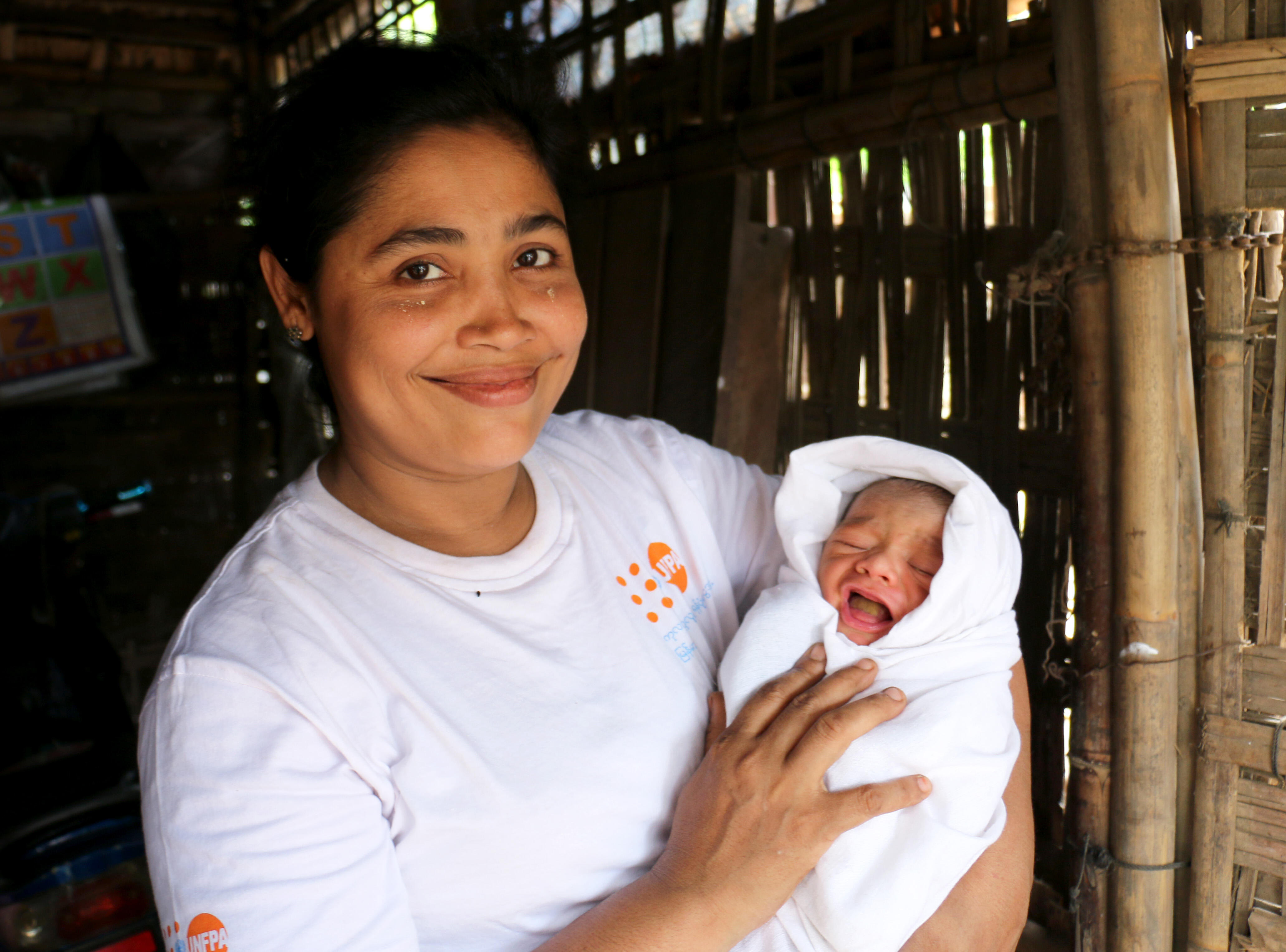 UNFPA-supported health volunteer Phyu Phyu Thant makes a home visit after a safe birth with a UNFPA clean delivery kit. Phyo Phyo lives and works in the Dar Paing camp for displaced people who identify as Rohingya in Myanmar’s Rakhine State.